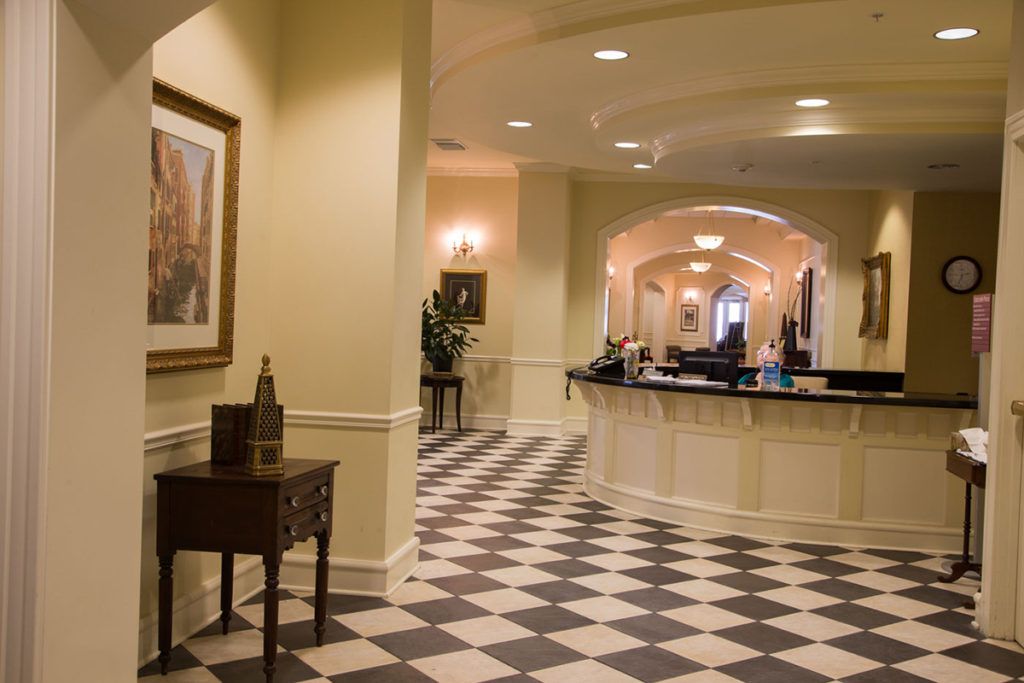 A hotel lobby featuring a checkered floor and reception desk.