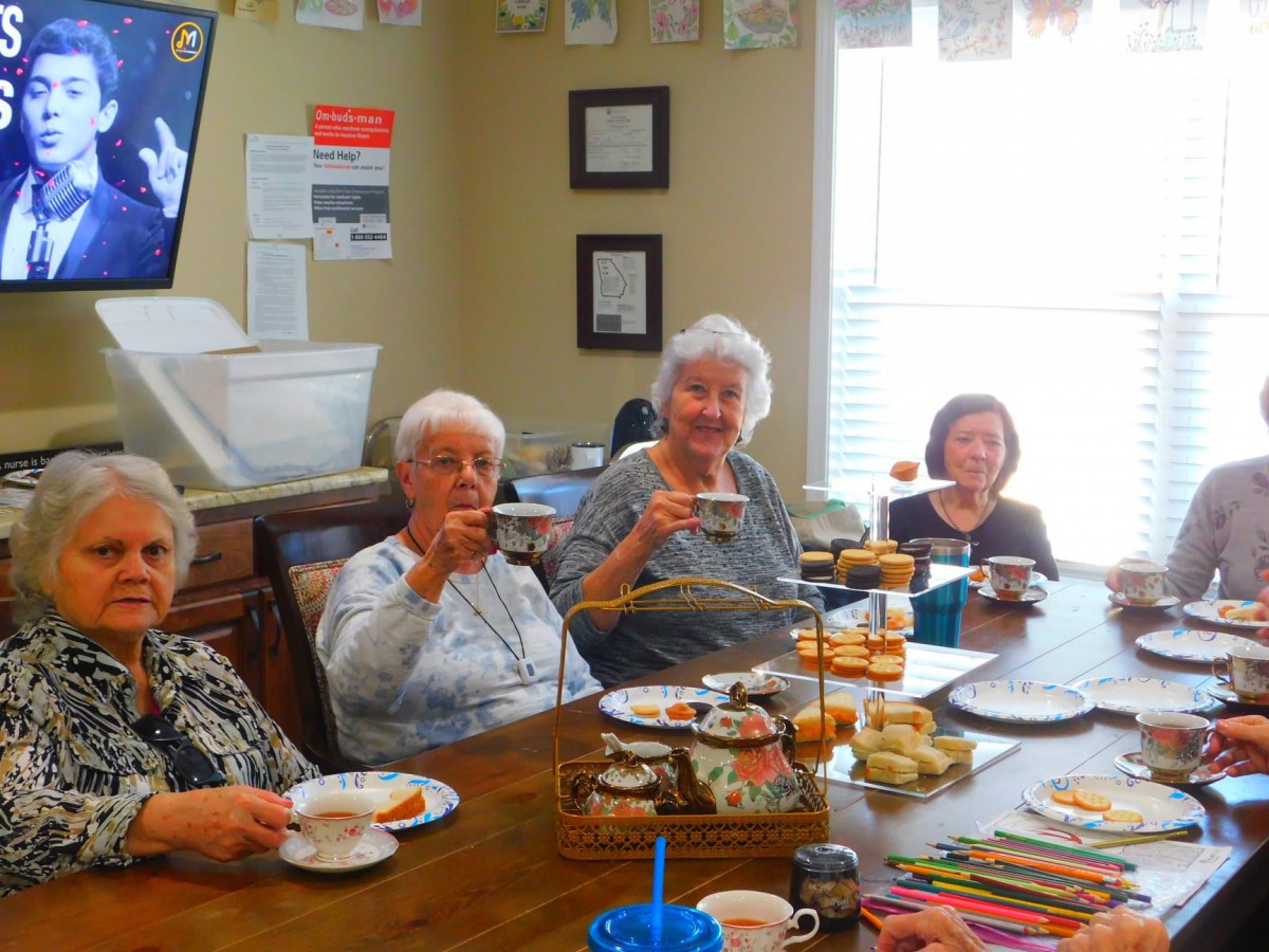 A group of seniors enjoying a tea party together indoors.