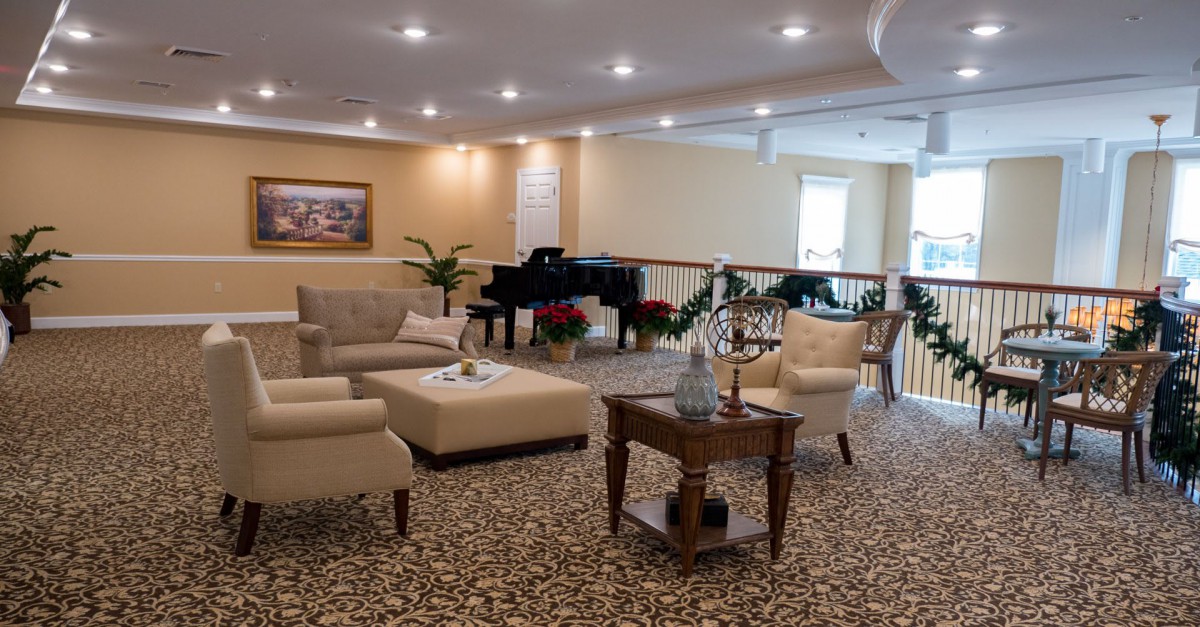 A cozy living room with comfortable seating and a piano.