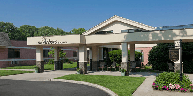 A building entrance with a covered canopy and landscaped surroundings.
