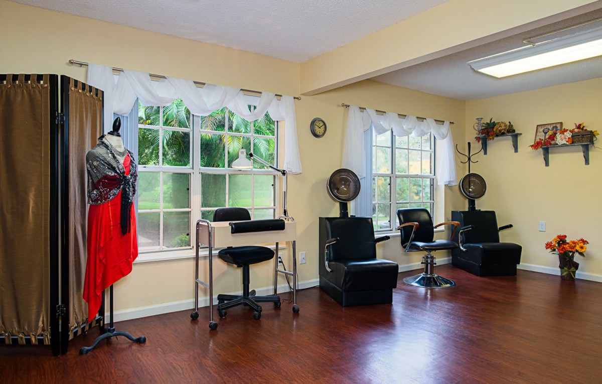 An inviting hair salon with stylish chairs, hair dryers, and a mannequin by the window.
