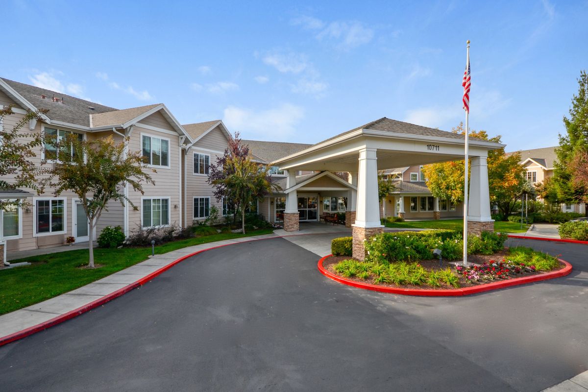 A residential building with a covered entrance and a well-maintained driveway.