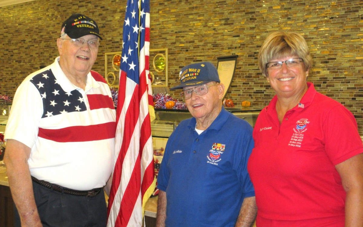 A group of people standing together with an American flag, showcasing a sense of community and patriotism.