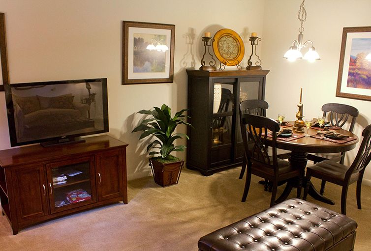 A cozy living room with a dining area, featuring warm lighting and elegant furniture.