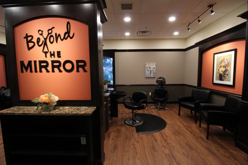 Interior view of a salon with hairstyling chairs and a welcoming waiting area.