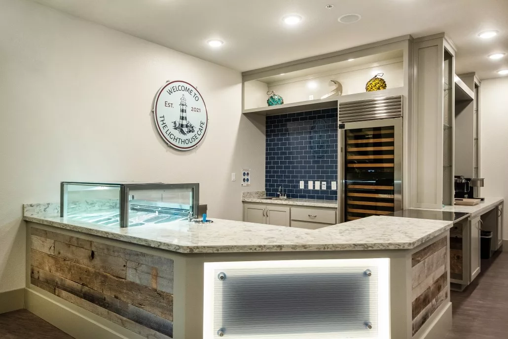 A modern kitchen interior featuring a marble countertop, built-in wine cooler, and a partial display case.