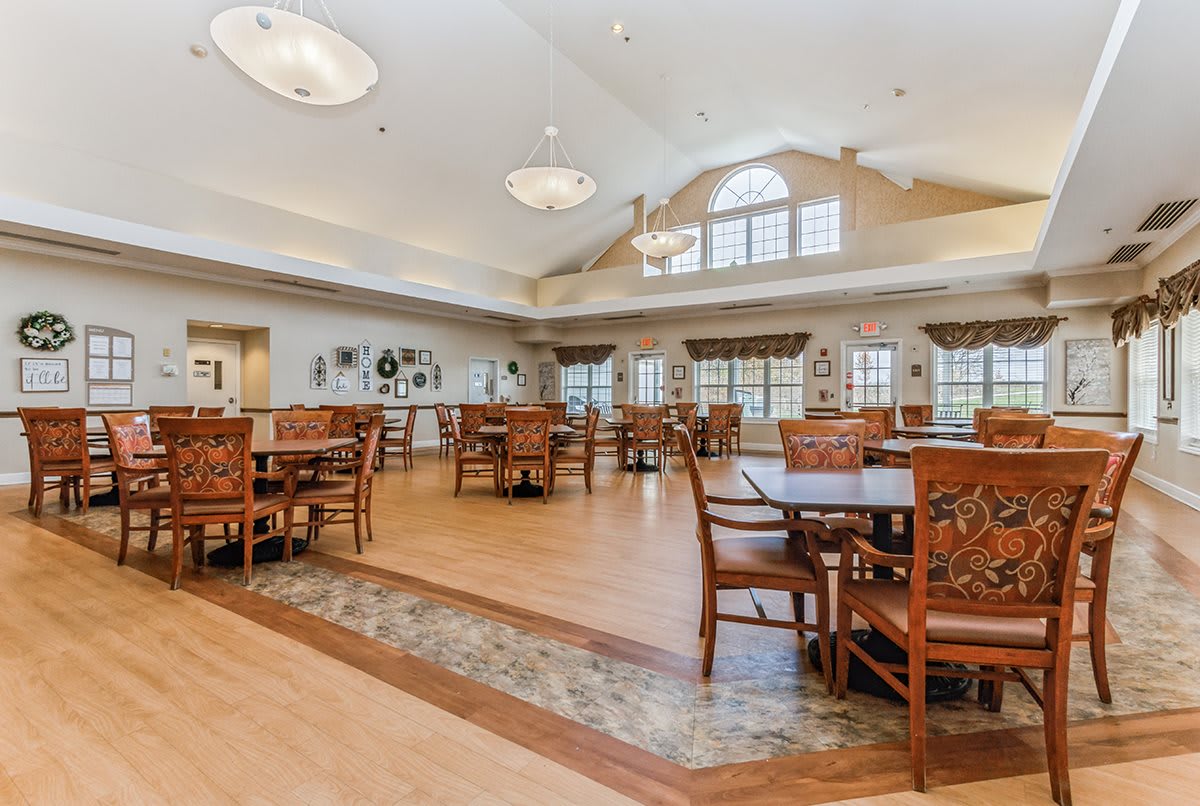A spacious dining room with wooden furniture and abundant natural light.