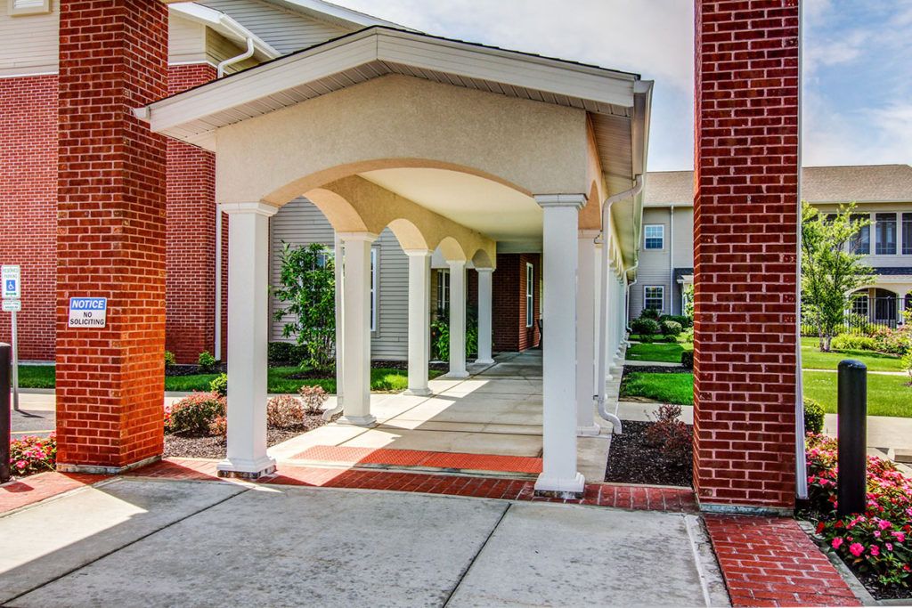 A covered walkway with columns leading to a building entrance.