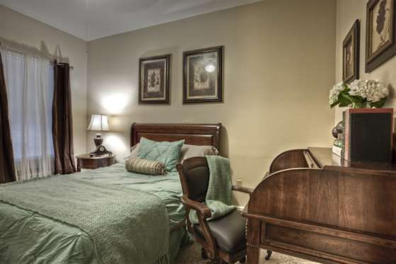 A cozy bedroom featuring a comfortable bed, elegant furniture, and warm lighting.