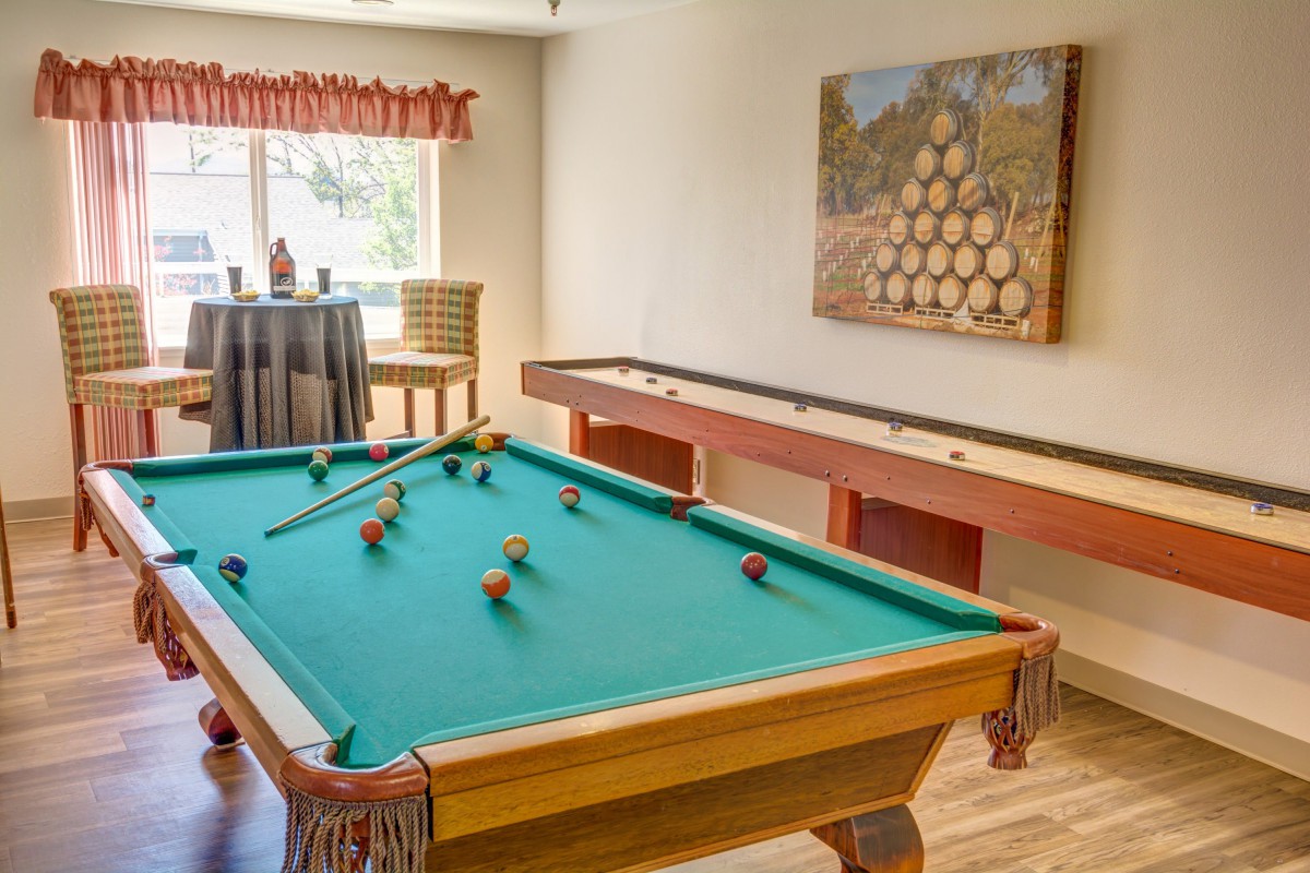 A cozy game room featuring a pool table and shuffleboard.