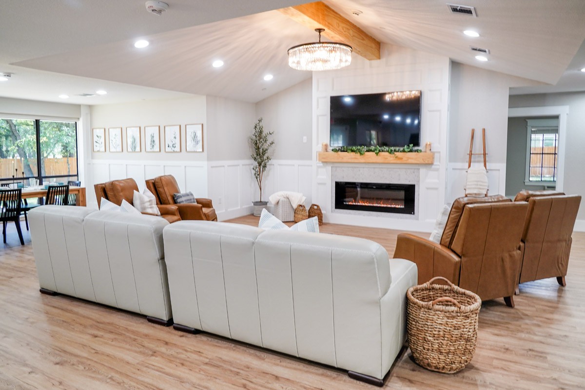 A modern living room with cozy seating and a fireplace.