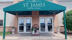 Entrance to St. James Manor & Villas with a welcoming floral display.