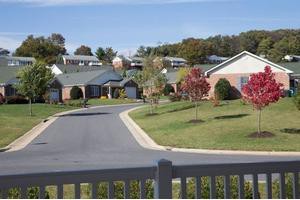 A peaceful suburban neighborhood with houses, trees, and a winding road.