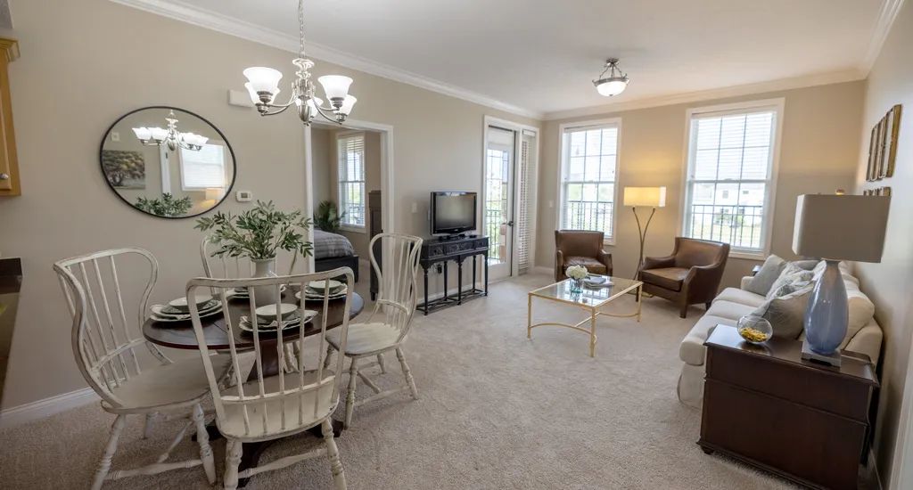 A cozy living room with a dining area, featuring elegant furniture and natural light.