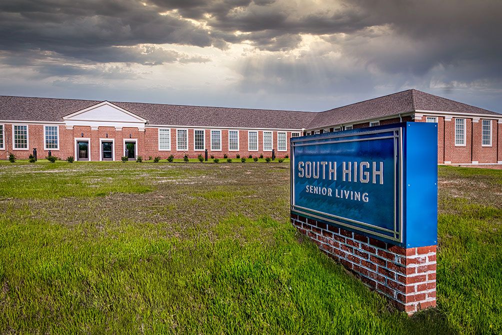 A school building with a sign reading 'South High' sits under a cloudy sky.