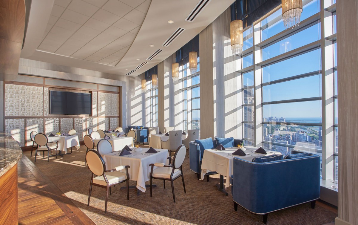 Elegant restaurant dining area with large windows and natural light.