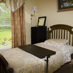 A cozy bedroom with a single bed and a view of the garden.