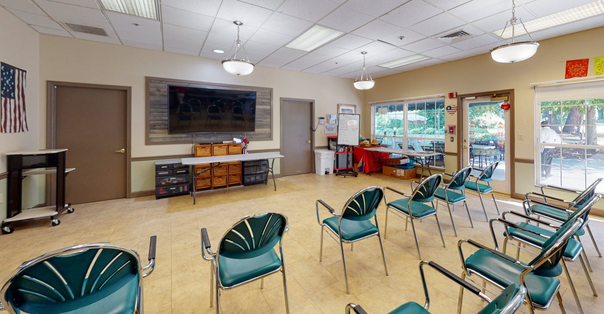 A classroom setting with chairs arranged facing a large television and a whiteboard.