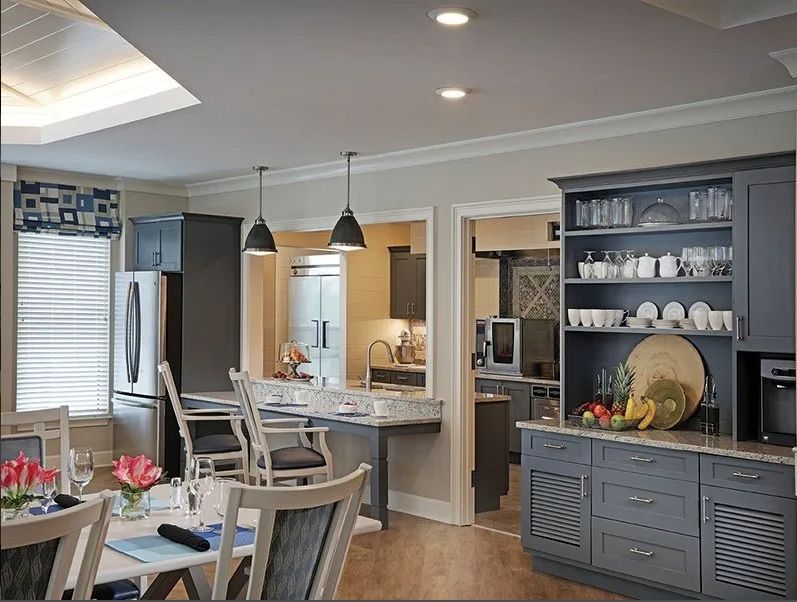 A modern kitchen and dining area with elegant lighting and cabinetry.