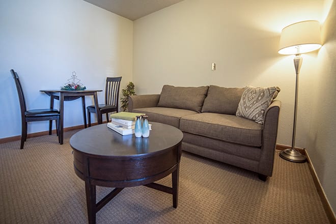 A cozy living room with a comfortable sofa and a round wooden coffee table.