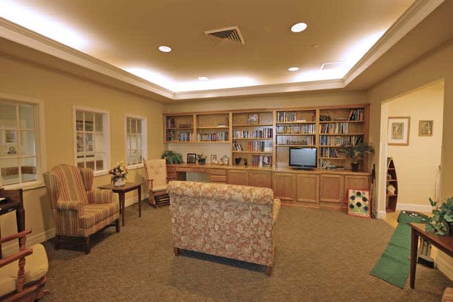 A cozy living room with a large bookshelf, comfortable seating, and a television.
