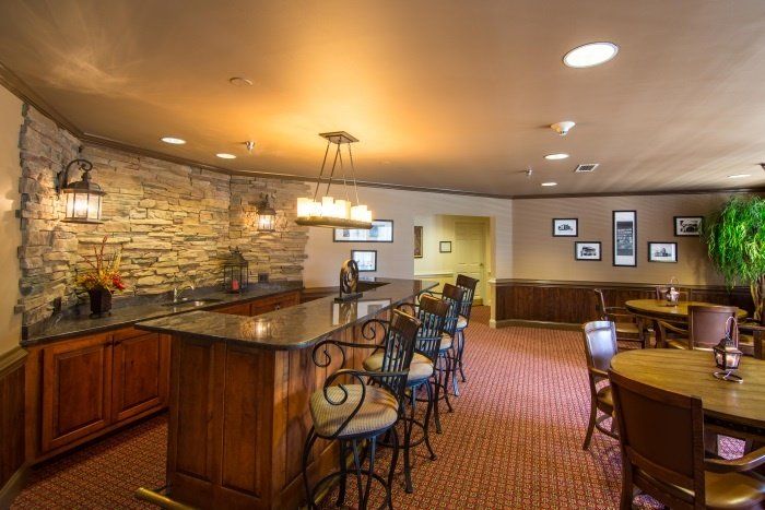 A cozy bar area with a countertop, seating, and warm lighting.