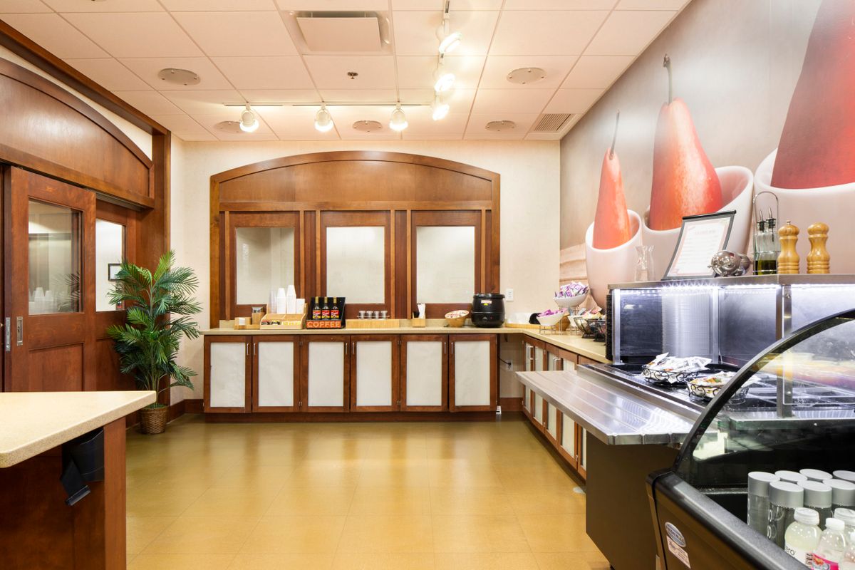 A cozy hotel breakfast area featuring a self-service coffee station and buffet setup.