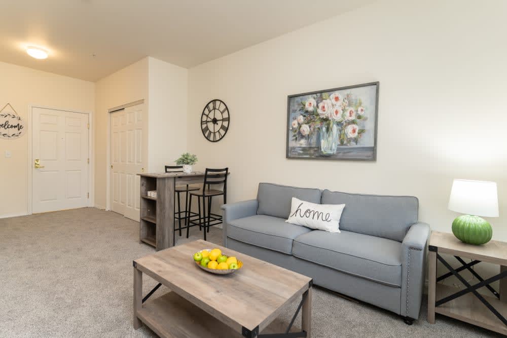 A cozy living room featuring a gray sofa, coffee table with lemon decor, and stylish wall art.