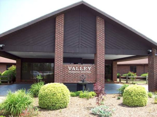 The entrance of the Valley establishment, showcasing modern brick architecture and well-maintained landscaping.