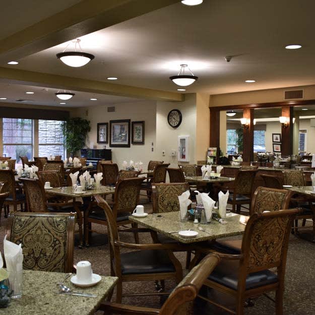 An empty restaurant dining area with neatly arranged tables and chairs.
