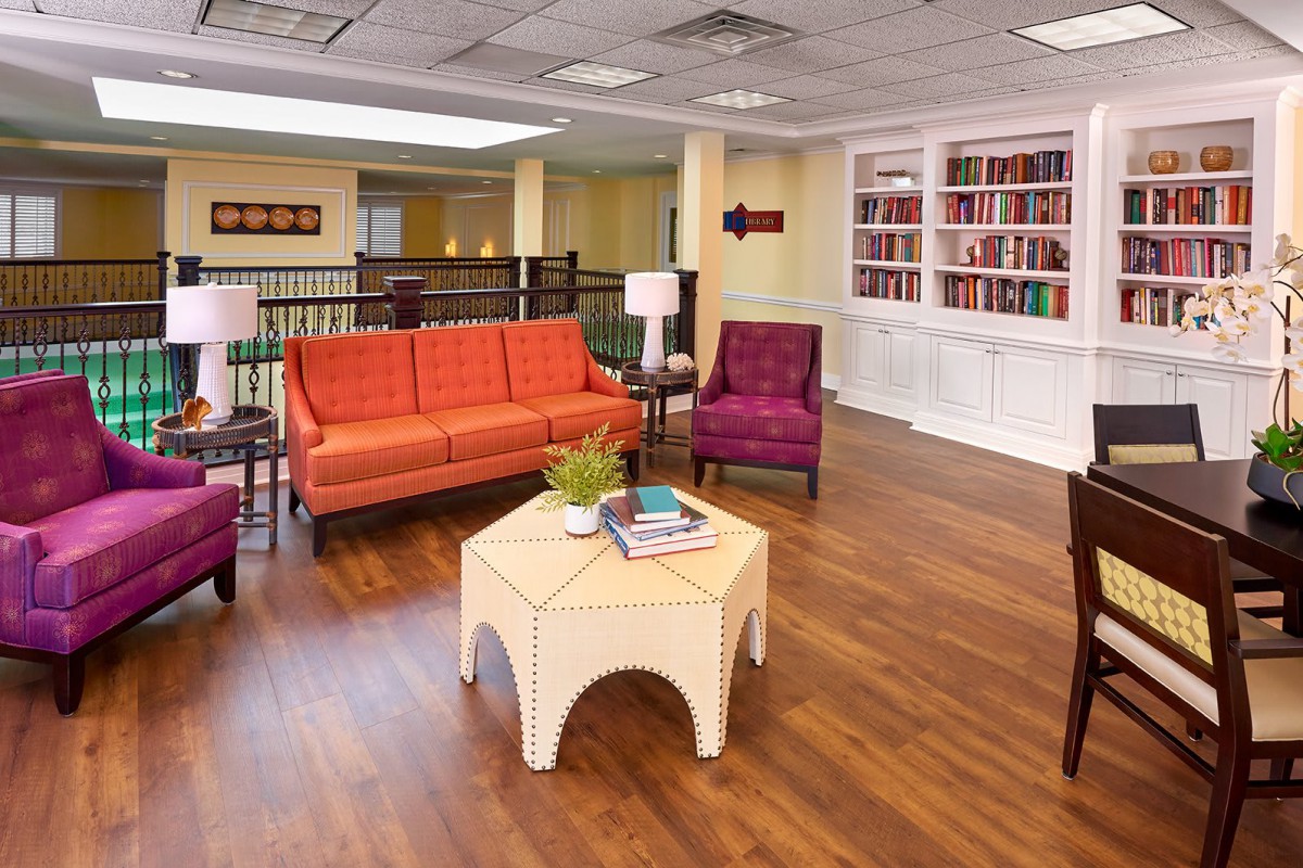 A cozy living room with vibrant furniture and a built-in bookshelf.
