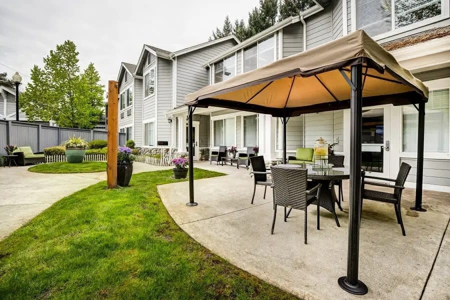 A well-furnished patio area with a canopy and outdoor seating next to a residential building.