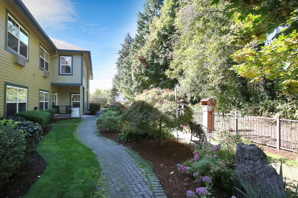 A charming house with a beautifully landscaped garden featuring a winding stone pathway and lush greenery.