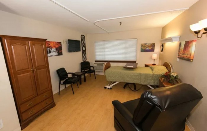 A therapy room with a treatment bed, chairs, and decorative elements.