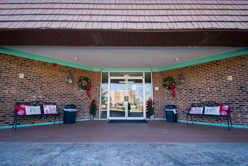 The festive entrance of a building adorned with holiday wreaths and benches.