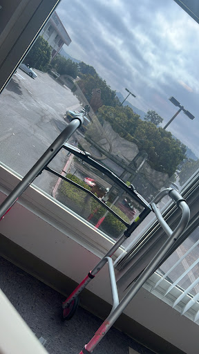 A walker positioned near a window, overlooking a parking lot.
