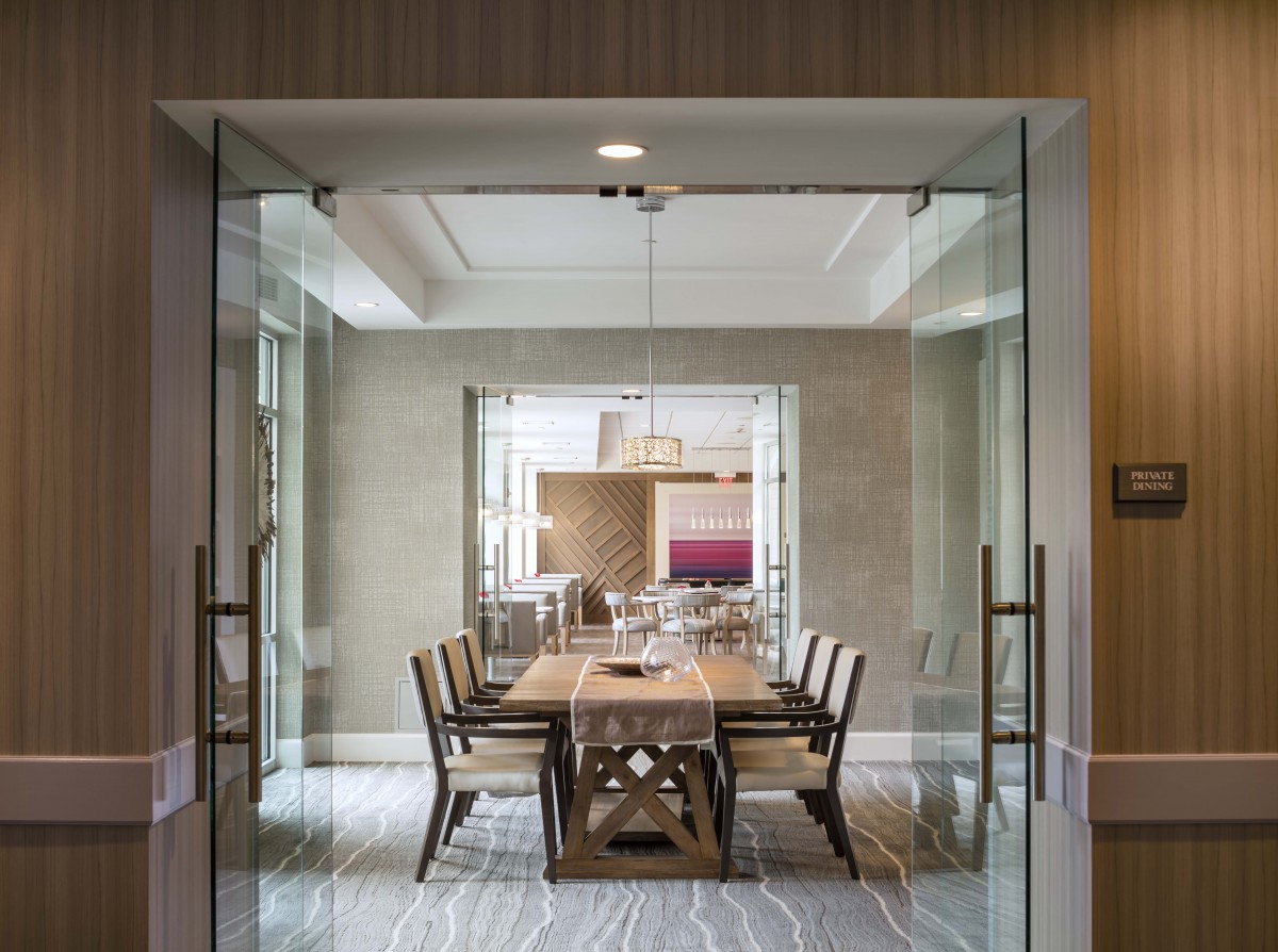 Elegant dining room with a wooden table and glass doors.