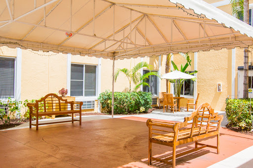 A cozy outdoor patio area with wooden furniture under a canopy, perfect for relaxation.