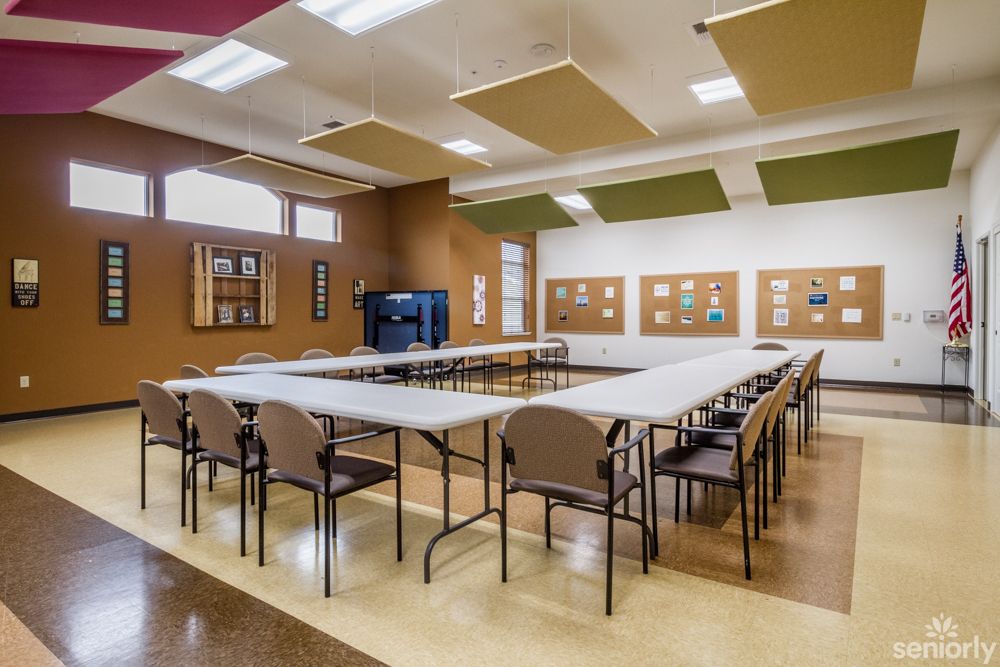 A modern conference room with tables and chairs arranged in a U-shape.
