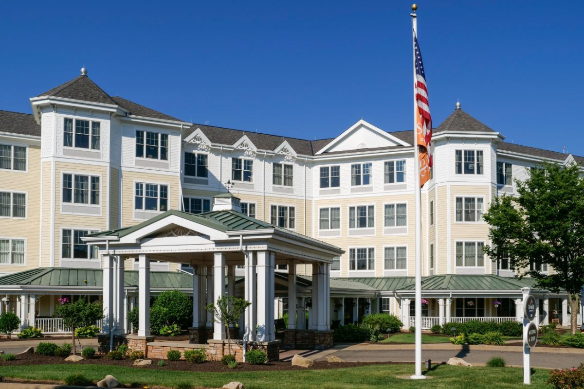 A four-story hotel building with a prominent American flag in front.