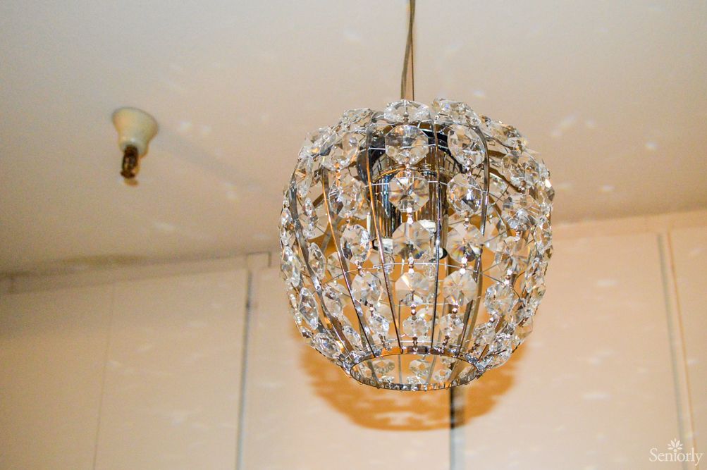 A crystal chandelier hanging from the ceiling, illuminating the interior space with a warm glow.
