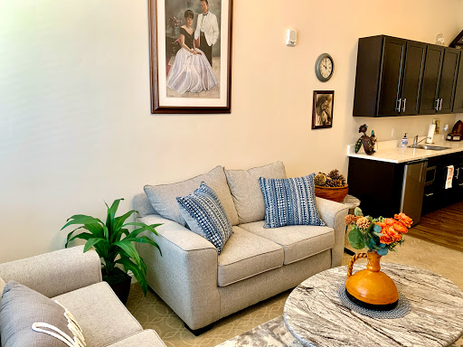 A cozy living room featuring a comfortable sofa, decorative artwork, and vibrant plants.