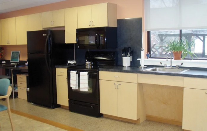 A modern kitchen with black appliances and light-colored cabinets.