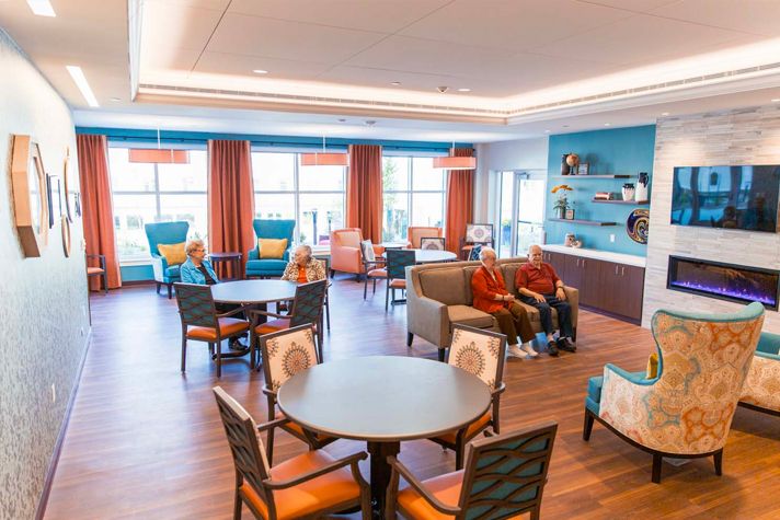 A welcoming living room with various seating arrangements and bright, colorful decor.