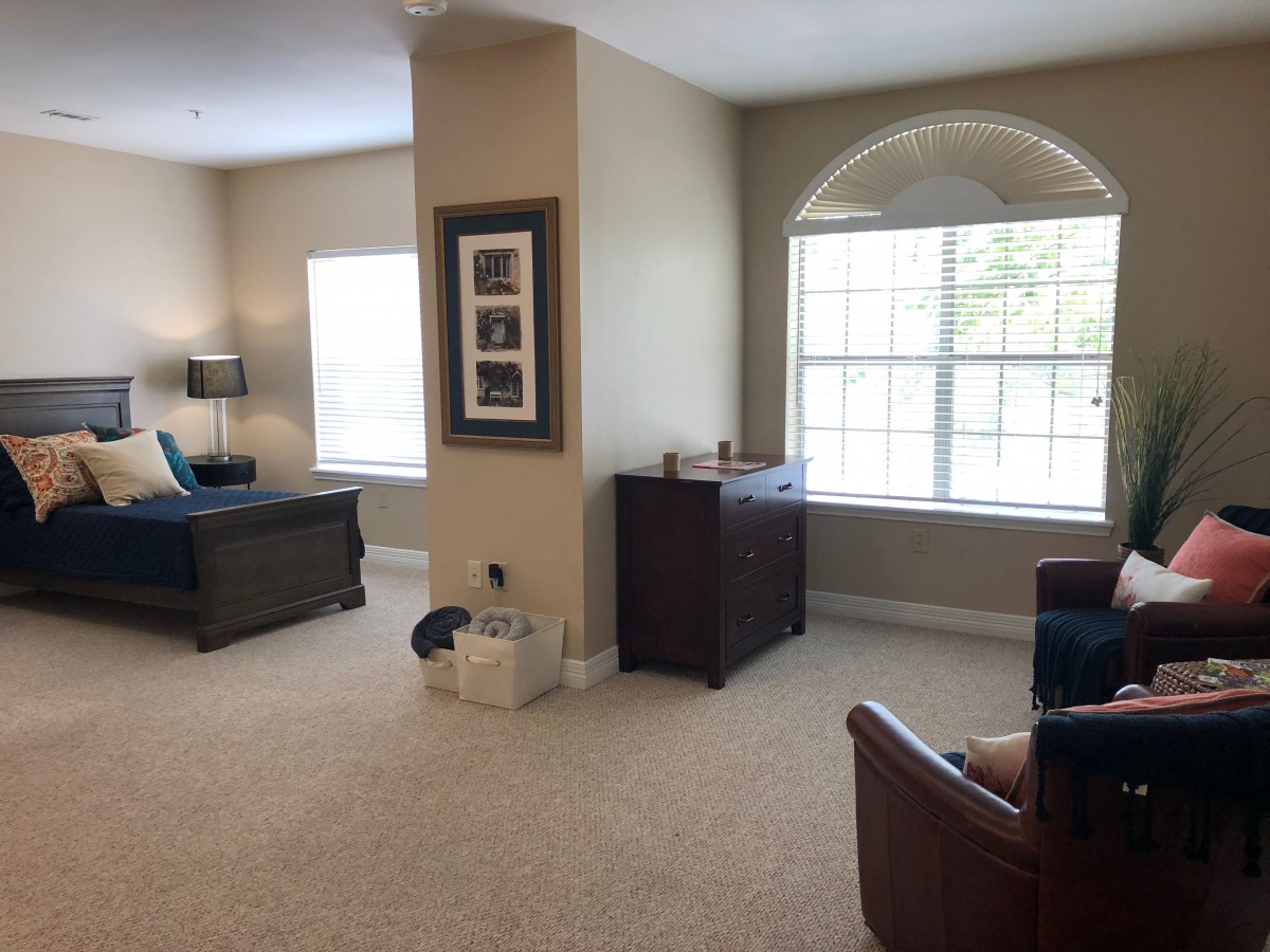 A spacious living room with large windows and comfortable furniture.