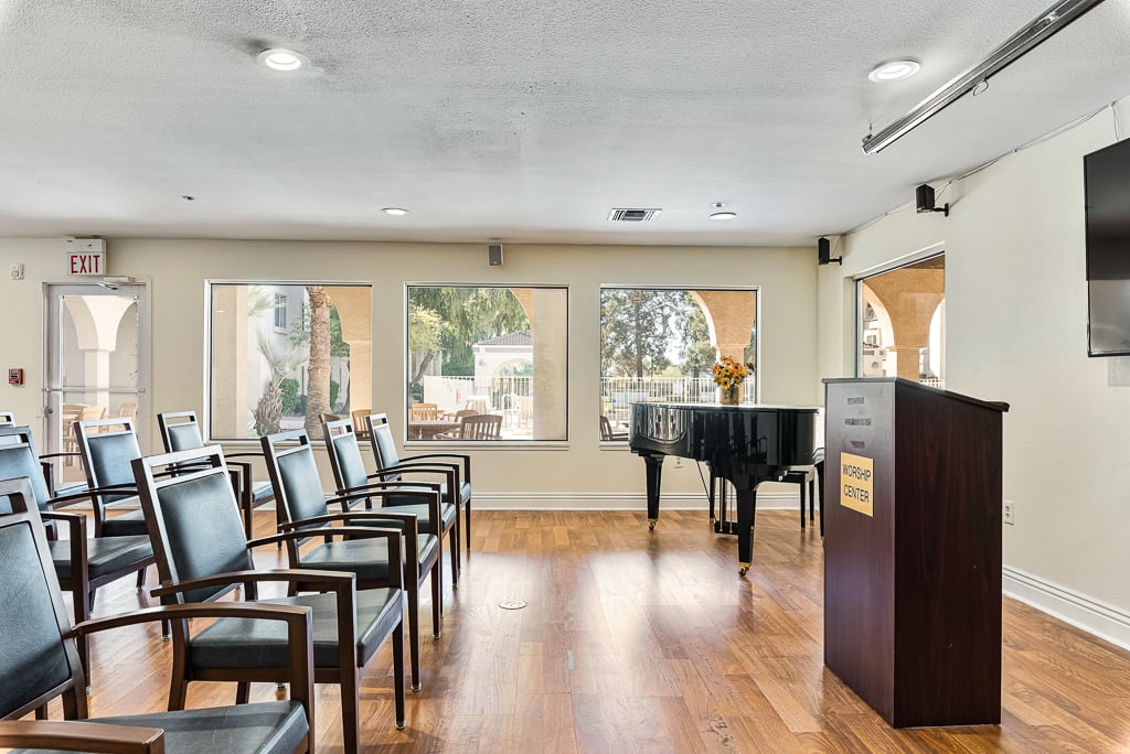 A conference room with seating, a grand piano, and a podium.