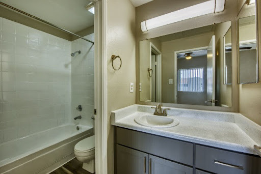 A modern bathroom featuring a shower, toilet, and sink with neutral-toned walls.