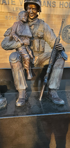 A bronze statue depicting a soldier holding a child, symbolizing protection and care.