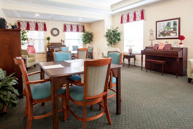 A cozy dining room with elegant furnishings and a piano.