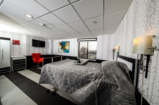 A modern hotel room featuring a comfortable bed, stylish furniture, and a view through the window.